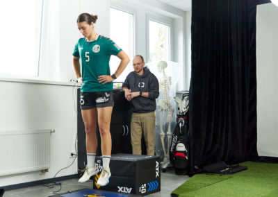 Sportlerin auf der Vibrationsplatte mit Personal Trainer und Physiotherapeut Malte Klett