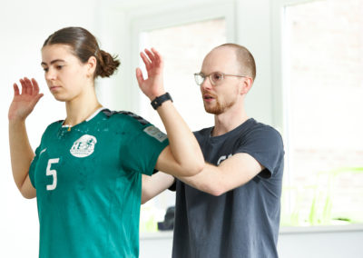 Sportlerin während der Therapie, Rückenübung mit dem Physiotherapeut Malte Klett
